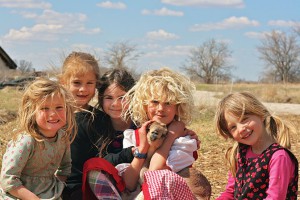 Welcoming the newest 'kid' to the village, baby goat Sorghum, a few of the kids spent the spring afternoon teaching him to run foot races and walk on a leash down Main Street. Photo by Josi