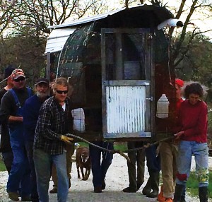 On Thursday, we witnessed a common sight at DR - a group of neighbors pitching in to help out, in this case moving a portable chicken house. Photo by Anna.