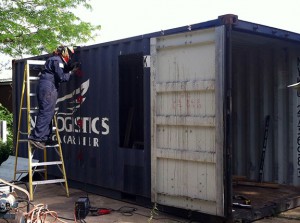 Frank of Deep Green Machine cuts the door into the shipping grocery store last summer. Photo by Nik.