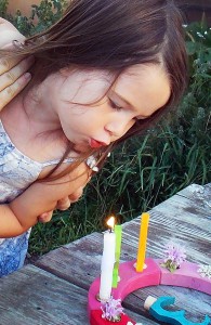Dancing Rabbit's youngest resident, Hazel, blows out a birthday candle. She's 3! Photo by Dennis.