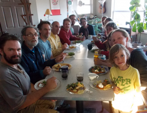 The newly-formed kitchen co-op sits down to a shared meal in Dancing Rabbit's Common House. Photo by Kurt.