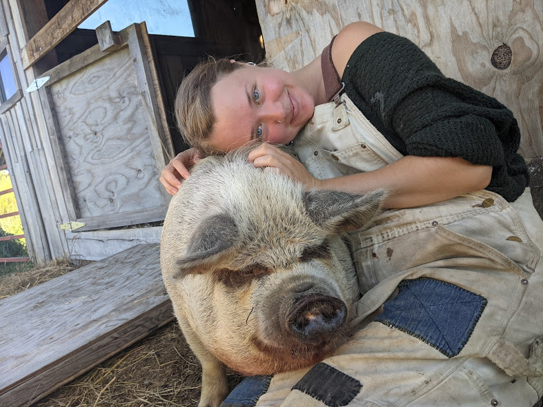 Emeshe embracing a pig